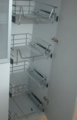 Cocina empotrada con laminado decorativo y perfiles metálicos Despensa con cestas metálicas